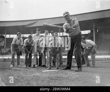 Une centaine de London Boys apprennent à jouer au baseball à la ville Blanche pour découvrir de jeunes talents de baseball , une centaine de garçons se sont inscrits pour des cours au stade de White City sous la direction de Doc Hayden , le directeur américain - entraîneur . Des gants de baseball de petite taille ont été fournis et les garçons ont reçu des instructions en fieldinf , en pitching et en batting . Les garçons qui montrent la plus haute promesse joueront l'année prochaine dans une nouvelle ligue juniour . Photos : Doc Hayden montrant les garçons comment frapper . 17 août 1936 Banque D'Images