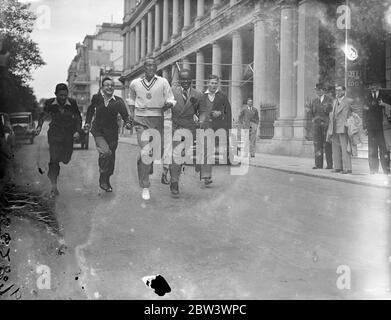 Jesse Owens fait de London Street son circuit . Jesse Owens , le ' Black Panther ' et vainqueur des médailles d'or olympiques de 3 , a présenté une démonstration aux garçons de Londres qui l'ont assiégé pour la corruption de ressources à son hôtel après son arrivée d'Allemagne . Owens doit participer à l'Empire britannique , à l'athlétisme des États-Unis à la ville Blanche ( samedi ) . Photos, Jesse Owens courant avec des garçons à l'extérieur de l'hôtel de Londres. 14 août 1936 Banque D'Images