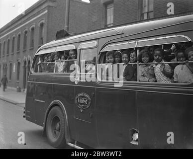 Légende originale suit (1936): Londres enfants de couleur ont une journée au bord de la mer. UNE fête d'enfants de couleur ont quitté Beckton Road , Canning Town , en autocar pour leur sortie annuelle à Southend . Photos montre , visages souriants dans la fenêtre de l'autocar que les enfants ont quitté . 18 août 1936 Banque D'Images