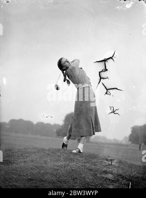 Eton court concurrent dans le championnat de golf pour filles . Une variété de styles de cheveux , allant des plaits aux cultures d'Eton , sont portés par des concurrents dans le championnat de golf filles ouvertes à Stoke Poges . Photos , les plaits de Mlle Audrey Taylor volant comme elle conduit . 9 septembre 1936 Légende originale de négatif Banque D'Images