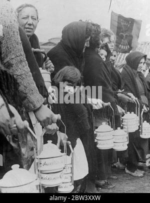 Elle avait faim , elle aussi . Une petite fille de Salamanque s'est emparée de son châle contre le froid alors qu'elle attendait dans une longue file d'attente pour recevoir de la nourriture de l'organisation d'aide d'hiver formée par les fascistes dans la partie de l'Espagne, fustigé par le général Franco pour soulager la détresse de la guerre civile . 10 mars 1937 Banque D'Images