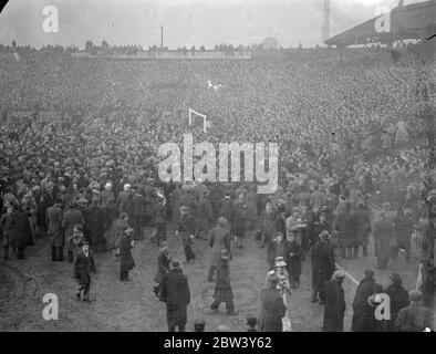 Les joueurs de Millwall fuient comme des milliers envahissent le terrain après la victoire de cravate de coupe . Les joueurs de Millwall devaient fuir du terrain lorsque des milliers de leurs supporters surjoints ont pris le terrain après la victoire de l'équipe sur Manchester City au sixième tour de la F A Cup à la « Den » , Nouvelle croix . Bientôt, tout le champ a été coincé avec des milliers de personnes . Photos montre , le terrain couvert avec des gens après son match . 6 mars 1937 Banque D'Images