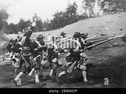 Le Soviet reconstruit la bataille historique pour les films. En abandonnant l'uniforme drab de l'armée moderne pour la robe colorée des anciens extras dans les studios de cinéma de Leningrad reconstruit les scènes historiques de la bataille de la guerre avec la Suède [Grande Guerre du Nord] pour le nouveau film soviétique Peter I. une des productions les plus ambitieuses du Soviet studios, le film est réalisé par Petrov. Il est basé sur le célèbre roman du même nom écrit par Tolstoy. Expositions de photos : troupes russes dans leurs uniformes colorés, faisant une charge à baïonnette pendant la réalisation du film aux studios Leningrad. 18 septembre Banque D'Images