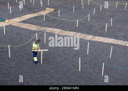 Les travailleurs préparent la plage avec des zones éloignées avec cordoned pour maintenir la distance sociale, à deux mètres de distance, et l'accès contrôlé pour le public pendant la phase t. Banque D'Images