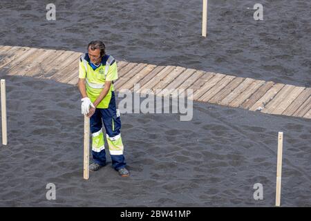 Les travailleurs préparent la plage avec des zones éloignées avec cordoned pour maintenir la distance sociale, à deux mètres de distance, et l'accès contrôlé pour le public pendant la phase t. Banque D'Images