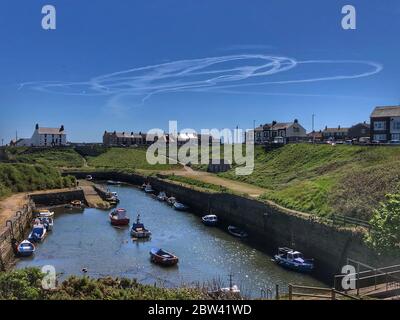 Deux avions contrefont des formes dans le ciel, comme vu du port de Seaton Sluice. Banque D'Images