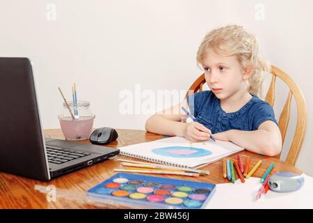 Fille enfant apprentissage art leçon en ligne sur l'Internet portable. Cours de peinture de dessin virtuel sur vidéo pendant l'auto-isolation à la maison. Vidéo distante Banque D'Images