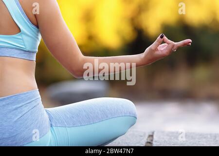 Gros plan de la main d'un jeune homme assis à l'intérieur de lotus pose. Concept d'exercice physique léger, zen et home yoga avec espace de copie. Concept de mode de vie sain. Banque D'Images