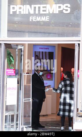 (200529) -- PARIS, le 29 mai 2020 (Xinhua) -- UN agent de sécurité remet du gel hydroalcoolique à un client à l'entrée du grand magasin du Printemps rouvert sur le boulevard Haussman à Paris, France, le 29 mai 2020. La France va encore se détendre après le 2 juin, en levant les restrictions de 100 km et en autorisant la réouverture d'entreprises, de parcs et de plages non essentiels, a annoncé jeudi le Premier ministre Edouard Philippe. Jeudi, la France avait 15,208 personnes hospitalisées avec le COVID-19, 472 de moins qu'une veille. Le nombre de patients en soins intensifs a chuté de 72 à 1, Banque D'Images