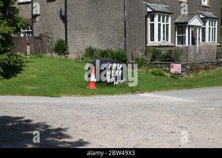 L'enseigne destinée aux visiteurs du Lake District se lit comme suit : 'y R U here' et 'Go home'. Vue à côté de la ferme dans la forêt de Grizedale le 28 mai 2020 Banque D'Images