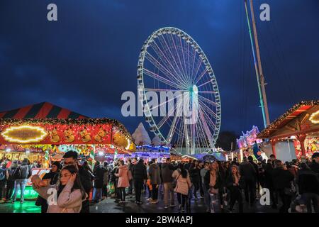 Foules aux stands de nourriture et aux manèges de funky, Winter Wonderland, Hyde Park, Londres, Royaume-Uni Banque D'Images