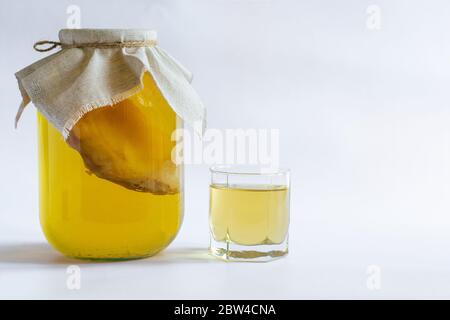 Kombucha boisson probiotique naturelle saine dans un pot en verre et un verre. Une alimentation adéquate. Sur un fond blanc avec espace pour le texte. Banque D'Images