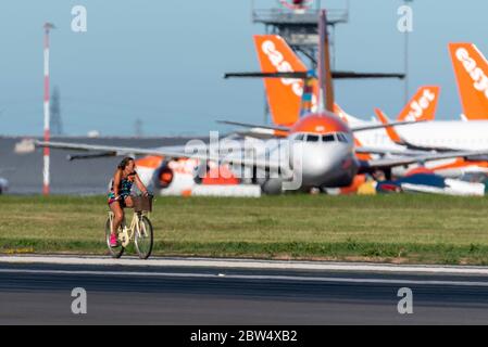 Aéroport de Londres Southend, Essex, Royaume-Uni. 29 mai 2020. Un cycle de course de charité a lieu sur la piste de l'aéroport de Southend pour recueillir des fonds pour le NHS. Normalement, l'aéroport serait trop occupé par les vols, mais la pandémie du coronavirus a interrompu les déplacements. EasyJet et Ryanair voteraient leurs horaires occupés à cette période de l'année, mais les avions de ligne sont garés. 40 membres de l'équipe de l'aéroport se sont portés volontaires pour courir ou parcourir la longueur de la piste par étapes, afin d'atteindre un total de 290 km - la distance jusqu'à l'une des destinations les plus populaires de l'aéroport - Amsterdam Banque D'Images