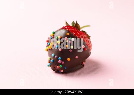 Fondue au chocolat. Fraise au chocolat sur fond rose Banque D'Images