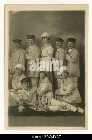 Portrait de la série de spectacles du studio de cartes postales du début des années 1920 avec des femmes vêtues de marins, portant des chapeaux de cuisinier, des hommes en casquettes, des vestes et des noeuds papillon, éventuellement H.M.S. Pinafore show, Dewsbury, West Yorkshire, Angleterre, Royaume-Uni