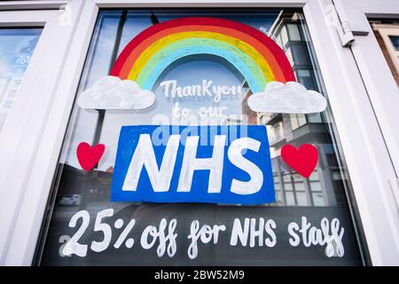 Des fenêtres récemment peintes, Merci NHS et un arc-en-ciel ont été peints sur un front de boutique à Manchester pour remercier tout le personnel de première ligne NHS. Banque D'Images