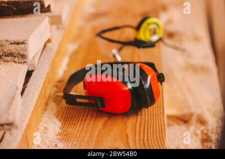 Gros plan sur l'équipement de protection professionnel pour les charpentiers et les travailleurs de la production du bois. Casque de protection, lunettes et mètre ruban sur j Banque D'Images
