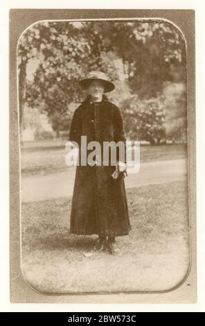 Copie du début des années 1900 d'une photo édouardienne prise d'un album de photos, représentant une femme dans un long manteau debout à l'extérieur, la photo originale est vers 1910, Royaume-Uni Banque D'Images