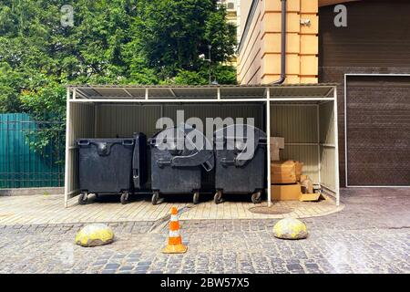 Poubelles pleines de déchets. Les déchets sont des tas de vider. Poubelles dans la ville ensoleillée. Le carton est groupé en balles. Banque D'Images