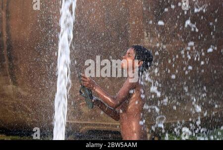 Prayagraj, Uttar Pradesh, Inde. 29 mai 2020. Des enfants battent sur une canalisation endommagée pendant une journée chaude dans le cadre du confinement de la COVID-19, à Prayagraj, le vendredi 29 mai 2020. Credit: Prabhat Kumar Verma/ZUMA Wire/Alamy Live News Banque D'Images