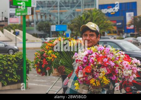 Homme péruvien vendant des fleurs dans la rue Banque D'Images