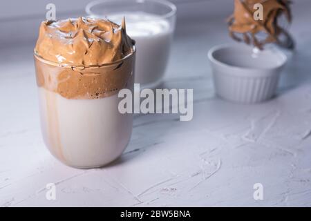 Café Dalgona dans un verre sur fond blanc. Café glacé moelleux coréen. Vue rapprochée. Banque D'Images