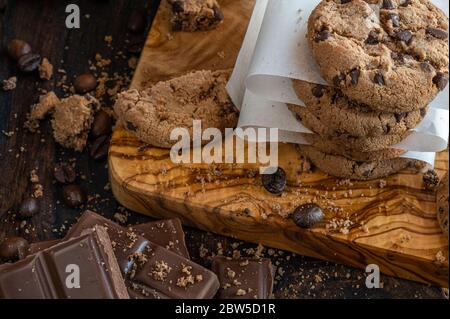 Biscuits et morceaux de chocolat sur une planche de bois Banque D'Images