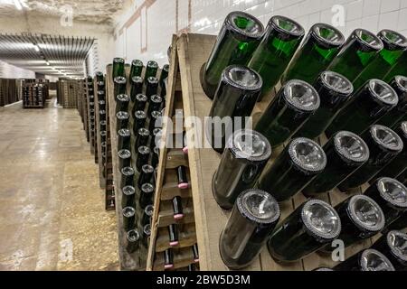 Des bouteilles de vin mousseux empilés dans ancienne cave à vin près de l'arrière-plan. Banque D'Images