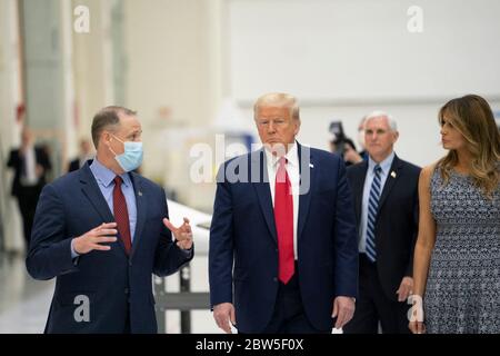 Le président Donald Trump et la première dame Melania Trump, écoutent l'administrateur de la NASA Jim Bridenstine lors d'une visite des capsules spatiales de l'équipage commercial Orion au bâtiment de soutien opérationnel du Centre spatial Kennedy, le 27 mai 2020 à Cape Canaveral, en Floride. Banque D'Images