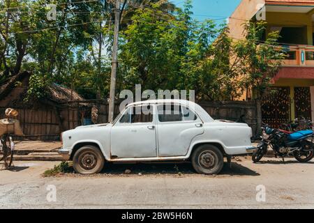 Une vieille voiture ingérée de l'ambassadeur de l'Hindustan garée dans une rue à Pondichéry, en Inde Banque D'Images