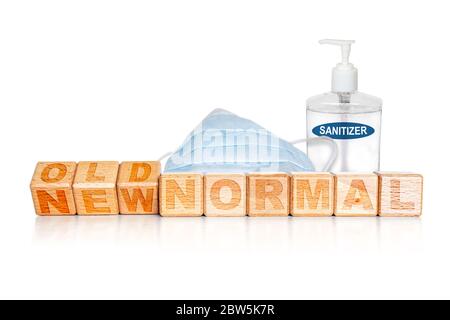 NOUVEAU MOT NORMAL sur les blocs de bois gravés avec retournement de l'ANCIEN avec le masque médical et désinfectant pour les mains. Concept de nouveau mode de vie normal à l'arrière Banque D'Images