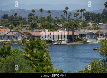 Vue sur le lac San Marcos dans le comté de San Diego, Californie, sur les résidences riveraines et les montagnes lointaines. Ponton, quai, palmiers, ensoleillé. Banque D'Images