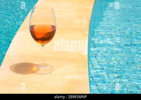 Verre de vin en bordure d'une piscine. Vin de rose dans un gobelet en verre. Concept de richesse. Banque D'Images