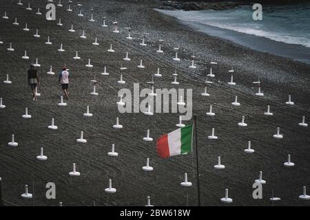 Gênes, Italie. 29 mai 2020. Les travailleurs se préparent à placer des parasols sur la plage de Gênes, Italie, le 29 mai 2020. Après que certaines restrictions imposées aux déplacements des gens depuis mars 10 avec le confinement ont été progressivement levées au cours des dernières semaines, le déplacement dans la même région de résidence n'a été autorisé qu'à partir de mai 18. La prochaine étape du calendrier officiel du gouvernement serait, en fait, de rouvrir le déménagement entre les régions italiennes d'ici juin 3. Crédit: Federico Tardito/Xinhua/Alamy Live News Banque D'Images