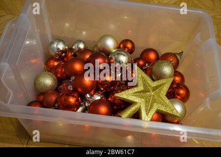 Décorations de Noël dans un coffret transparent. Boules argentées et rouges avec une étoile dorée. Banque D'Images