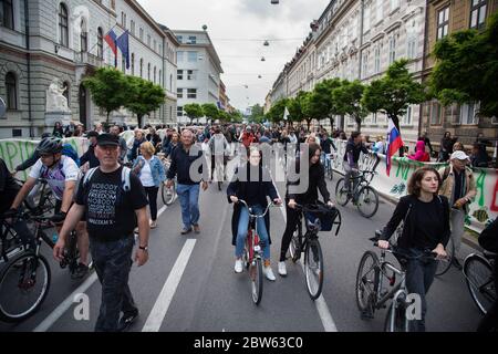 Ljubljana, Slovénie. 29 mai 2020. Des manifestants antigouvernementaux passent à vélo et à pied devant les bâtiments du gouvernement pendant la manifestation.chaque vendredi, des milliers de personnes à Ljubljana protestent contre le gouvernement du Premier ministre Janez Janša, dans un climat de corruption et de régime antidémocratique. Crédit : SOPA Images Limited/Alamy Live News Banque D'Images