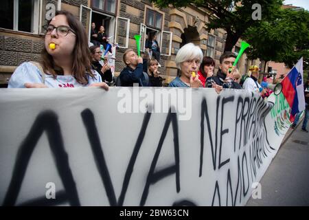 Ljubljana, Slovénie. 29 mai 2020. Des manifestants anti-gouvernementaux font des sifflements tout en tenant une grande bannière pendant la manifestation.chaque vendredi, des milliers de personnes à Ljubljana protestent contre le gouvernement du Premier ministre Janez Janša, dans un contexte de corruption et de régime antidémocratique. Crédit : SOPA Images Limited/Alamy Live News Banque D'Images