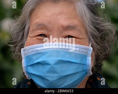 Une femme vietnamienne âgée porte un masque chirurgical jetable lors de la pandémie de 2019/20 du virus corona. Banque D'Images