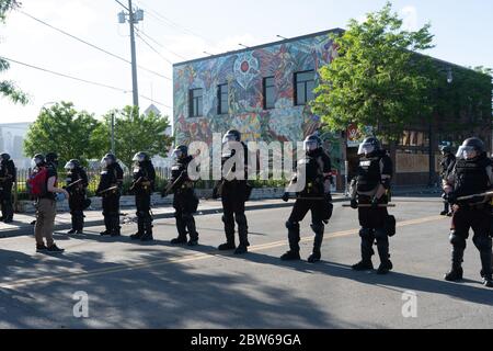 homme face à des policiers de patrouille d'état qui se tiennent à la garde des émeutes de minneapolis et qui contrôlent les manifestants et les manifestants avec des clubs Banque D'Images