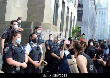 29 mai 2020, New York, New York, États-Unis : de grandes foules se sont emmenées dans les rues de New York pour protester contre la mort de George Floyd et des cas de brutalité policière pour la deuxième journée consécutive. Des centaines, à visage masqué, se sont rassemblées sans appliquer de distanciation sociale sur Foley Square devant la Cour de justice de Manhattan, criant leur colère et appelant le Conseil municipal à réintroduire et à passer un projet de loi de chokehold. Cette femme masquée crie sur une femme officier du NYPD. La nuit, les manifestations à Brooklyn ont tourné à la violence, avec une douzaine d'officiers du NYPD blessés et au moins 120 arrestations. (Crédit Imag Banque D'Images