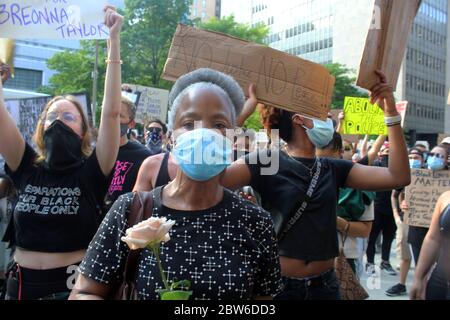 29 mai 2020, New York, New York, États-Unis : de grandes foules se sont emmenées dans les rues de New York pour protester contre la mort de George Floyd et des cas de brutalité policière pour la deuxième journée consécutive. Des centaines, à visage masqué, se sont rassemblées sans appliquer de distanciation sociale sur Foley Square devant la Cour de justice de Manhattan, criant leur colère et appelant le Conseil municipal à réintroduire et à passer un projet de loi de chokehold. Cette femme masquée au visage montre avec une rose à la main. La nuit, les manifestations à Brooklyn ont tourné à la violence, avec une douzaine d'officiers du NYPD blessés et au moins 120 arrestations. (Crédit Imag Banque D'Images