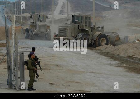 Des bulldozers militaires israéliens bloquent la route peu après que le convoi blindé quitte la bande de Gaza par le passage de Kissufim qui a conduit au bloc 'Gush Katif' des colonies israéliennes dans la bande de Gaza alors qu'Israël met fin à son occupation du territoire palestinien de 38 ans. Banque D'Images