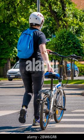 Homme avec un vélo traversant la rue. Homme marchant à côté de son vélo, la bonne voie de croos la route avec un vélo Banque D'Images