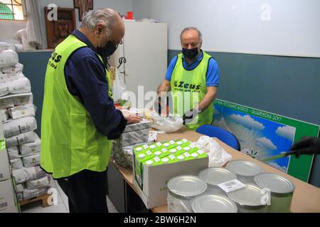 Pendant l'urgence mondiale de Covid-19, de nombreuses familles ont perdu leur emploi en raison de la fermeture de diverses activités productives et commerciales. Le manque d'argent pour l'achat de nourriture a conduit de nombreuses familles à une crise sans précédent. Dans leur aide sont intervenus l'association volontaire et caritas de l'Église catholique. Ils ont recueilli de la nourriture et des boissons donnés par des particuliers et des fabricants et organisé une importante chaîne de distribution aux familles les plus nécessiteuses.volontaires de l'Église de notre-Dame de Carmine à la table de travail dans la préparation des paquets à livrer aux familles dans Banque D'Images