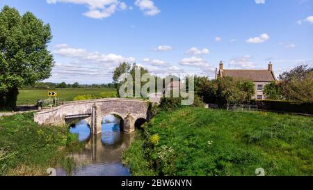 Un joli cottage de village à côté d'une rivière de campagne dans le Somerset. Banque D'Images