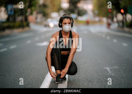 Femme coureur portant un masque médical. Course dans le parc. Pandémie de coronavirus Covid-19. Sport, vie active en quarantaine chirurgical stérilisation masque facial Banque D'Images