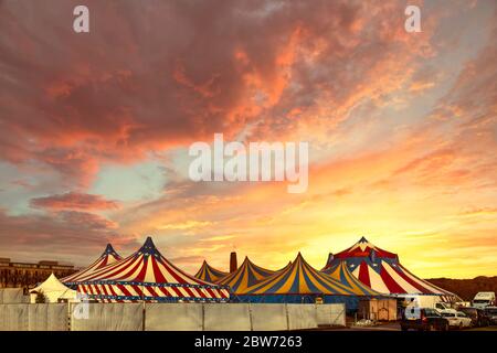 Tentes de cirque rouge et blanc surmontées d'une couverture bleu bleu clair avec des nuages Banque D'Images