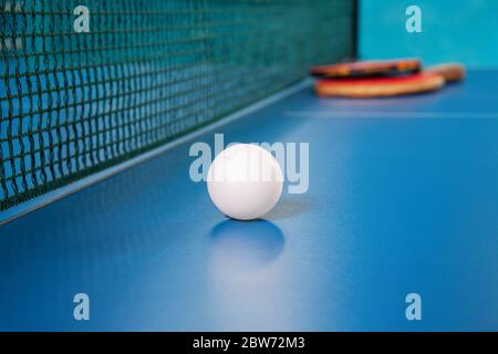 Raquettes pour le tennis de table de couleur rouge et une balle sur une table de tennis Banque D'Images