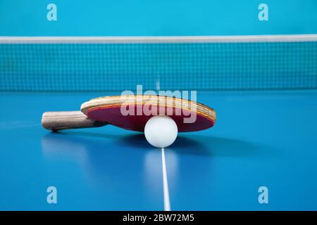 Raquette pour tennis de table de couleur rouge et ballon sur une table de tennis Banque D'Images