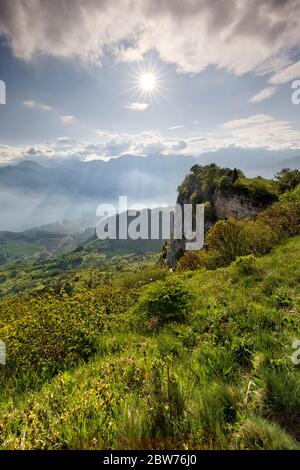 Le mur rocheux du mont Creino surplombe le lac de Garde immergé dans la brume. Alto Garda, province de Trento, Trentin-Haut-Adige, Italie, Europe. Banque D'Images